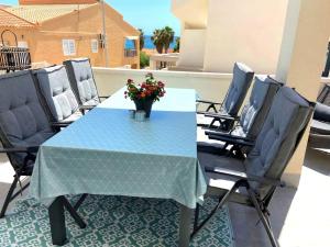 a blue table with chairs and a vase of flowers at Casa puerto Isla Plana - Grande in Isla Plana