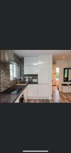 a kitchen with white cabinets and a counter top at 20 Holiday Cottage, East End Ballybunion in Ballybunion