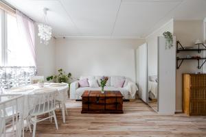 a living room with a table and a couch at Unique wooden house apartment with separate office room in Turku