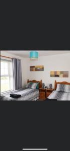 a bedroom with two beds and a window at 20 Holiday Cottage, East End Ballybunion in Ballybunion