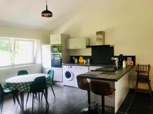 a kitchen with a table and a washing machine at Gîte de Saint-Christophe 