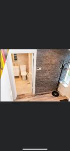 een badkamer met een toilet en een bakstenen muur bij 20 Holiday Cottage, East End Ballybunion in Ballybunion