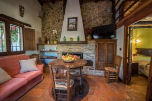 een woonkamer met een tafel, een bank en een open haard bij Al Agia - Los Molinos de Padul in Padul