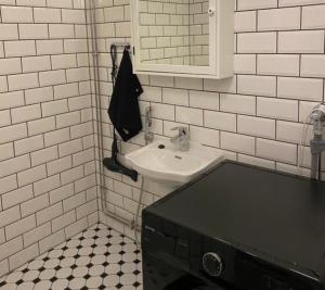 La salle de bains blanche est pourvue d'un lavabo et d'un miroir. dans l'établissement NO:4, à Vaasa
