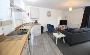 a kitchen and a living room with a couch at Strand House Flat 2 Free Parking, by RentMyHouse in Exmouth