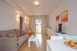 a living room with a couch and a tv at Apartamentos Vista Alegre Mallorca in Porto Cristo