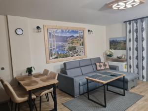 - un salon avec un canapé bleu et une table dans l'établissement Apartamenty Convallis, à Kościelisko