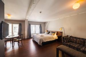 B&B Kwaadham 52 - Music Hotel Ghent في خنت: غرفة نوم بسرير وطاولة واريكة