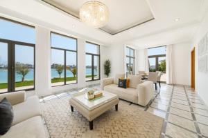 a living room with white furniture and large windows at Maison Privee - Luxury Villa with Dramatic View Private Beach & Pool in Dubai