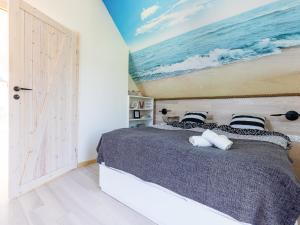 1 dormitorio con 1 cama y una pintura del océano en Dom nad Zatoką, en Puck