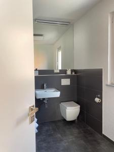 a bathroom with a white toilet and a sink at Gästehaus Schattemorellsche 