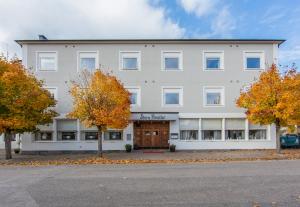 a large white building with trees in front of it at Stora Hotellet Markaryd in Markaryd