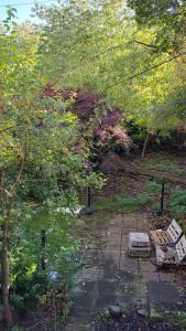 um jardim com dois bancos sentados num caminho de pedra em The Broughton Road Residence em Edimburgo