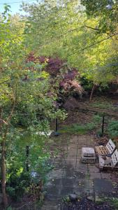 a garden with two benches sitting on a stone path at The Broughton Road Residence in Edinburgh