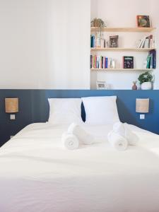 een wit bed met 2 opgerolde handdoeken bij Le Cocoon - Appartement cocooning à Orange in Orange