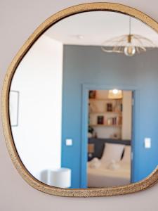 een spiegel aan een muur met een woonkamer bij Le Cocoon - Appartement cocooning à Orange in Orange
