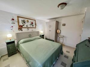 a bedroom with a bed with a green comforter at I Due Gradoni Stone House in Pacentro