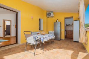 una cucina con tavolo, sedie e parete gialla di Seahouserent a Cannigione