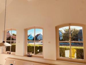 - trois fenêtres dans une chambre avec vue sur la cour dans l'établissement Cadzandkerkje, à Cadzand