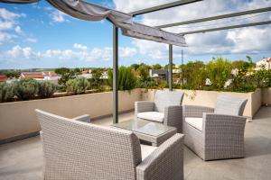 patio z wiklinowymi krzesłami i szklanym stołem w obiekcie Penthouse FraVita Medulin w Medulinie
