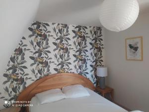 1 dormitorio con 1 cama y papel pintado con motivos florales en Gîte Les Gorges du Tarn en La Cresse