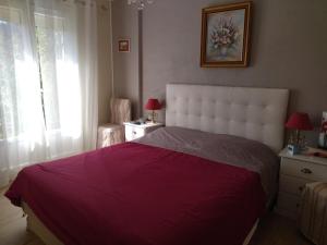 a bedroom with a large bed with a purple blanket at les petites roches in Saint-Fortunat-sur-Eyrieux