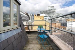 a balcony with a table and two chairs on it at Crane Court by City2Stay in London