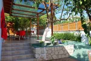 un patio con escaleras, una mesa y un árbol en Stela Apartments, en Ksamil