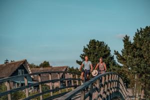 twee personen die fietsen op een houten brug bij Beach Resorts Makkum in Makkum