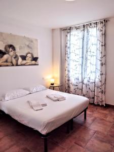 a bedroom with a large bed with white sheets at Affittacamere di Andrea Bertolino Argelato in Argelato