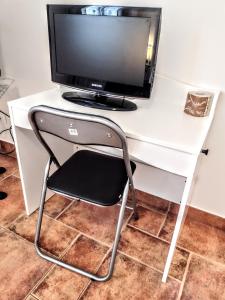 un monitor de ordenador sentado en la parte superior de un escritorio blanco en Affittacamere di Andrea Bertolino Argelato, en Argelato
