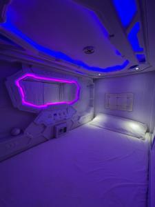 a small room with a bed with purple lights at Destino Cobisa in Cobisa