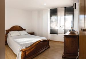 um quarto com uma cama de madeira e uma janela em Destino Cobisa em Cobisa