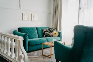 salon z zieloną kanapą i 2 krzesłami w obiekcie Hotel Palais26 w Villach