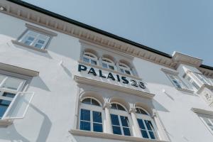 a white building with a sign on the side of it at Hotel Palais26 in Villach