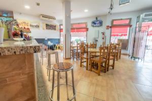 un restaurante con sillas y mesas y un bar en Albergue Rojo Plata, en Torremegía