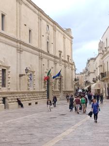 een groep mensen die voor een gebouw lopen bij La Dimora dei Professori DiffusHotel in Lecce