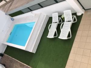 an overhead view of two chairs and a swimming pool at LCC rooms in Couço