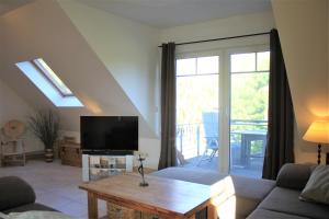 a living room with a couch and a tv at Sonnendeck in Kaltenhof