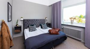 a bedroom with a bed with a purse on it at Stora Hotellet Markaryd in Markaryd