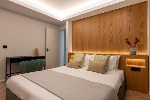 um quarto com uma cama grande e uma parede de madeira em Phaedrus Living Luxury Penthouse Ploutarchou em Atenas
