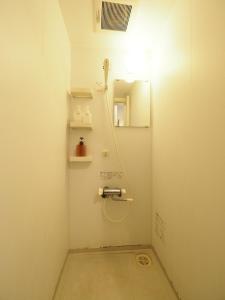 ein Bad mit einer Dusche und einem Spiegel in der Unterkunft i home Tsubogawa / Vacation STAY 53028 in Naha
