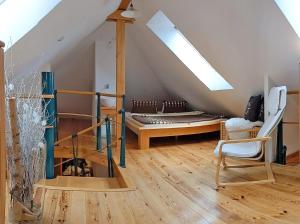 a attic room with a bed and a chair at Apartmán Brasserie Avion in Rožnov pod Radhoštěm