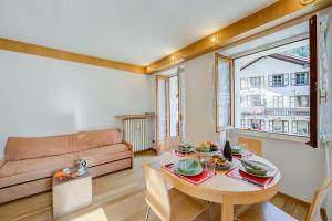 sala de estar con mesa y sofá en Monterosa Cozy Apartment 200mt From Ski, en Macugnaga