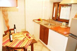 eine Küche mit einem Tisch und einem Waschbecken mit einer Flasche Wein in der Unterkunft Appartamento Iris in Massa Marittima