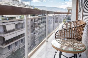 uma varanda com uma mesa e uma cadeira num edifício em Phaedrus Living Luxury Penthouse Ploutarchou em Atenas