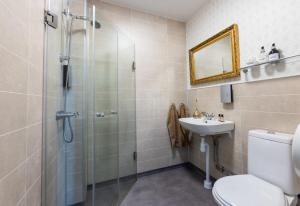 a bathroom with a shower and a toilet and a sink at Stora Hotellet Markaryd in Markaryd +25 photos