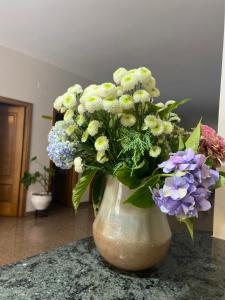 un jarrón lleno de flores blancas y moradas en un mostrador en A Mariña, en Cambados