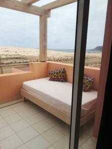 a bed in a room with a view of the beach at Residence Por Do Sol, Praia Cabral, Boa Vista, Cape Verde, FREE WI-FI in Sal Rei