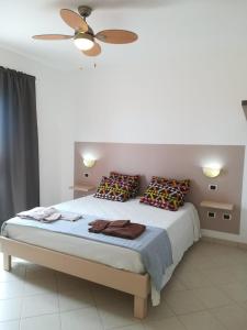 a bedroom with a bed with pillows and a ceiling fan at Residence Por Do Sol, Praia Cabral, Boa Vista, Cape Verde, FREE WI-FI in Sal Rei